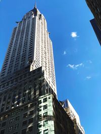 Low angle view of modern buildings against blue sky