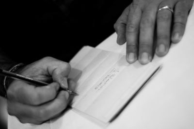 Close-up of hand holding book with text