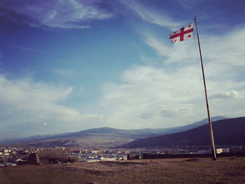 Flag in front of mountains against sky