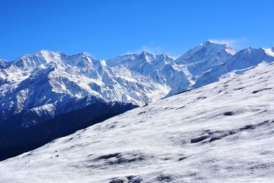 Scenic view of snowcapped mountains against clear blue sky