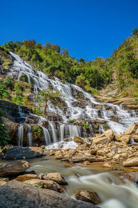 Scenic view of waterfall against sky