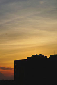 Silhouette buildings against sky during sunset