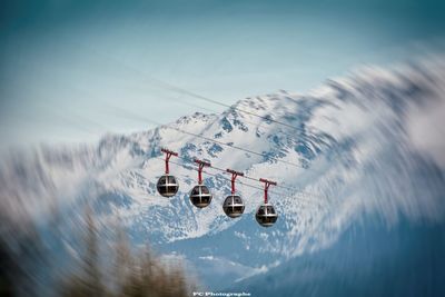 Overhead cable car over snowcapped mountains against sky