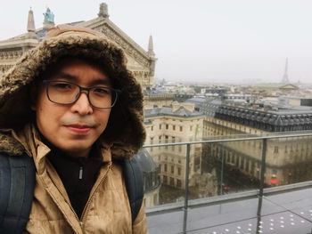 Portrait of man in city against buildings