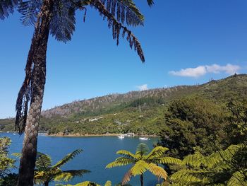 Scenic view of lake and mountains against blue sky