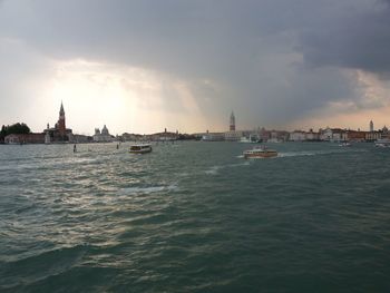 Boats in sea against buildings in city