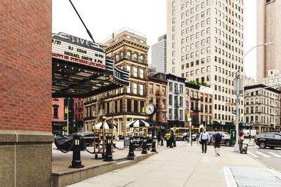 People on street amidst buildings in city