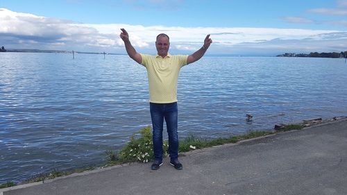 Full length of woman standing in sea against sky