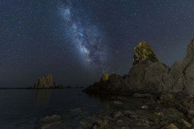 Scenic view of lake against sky at night
