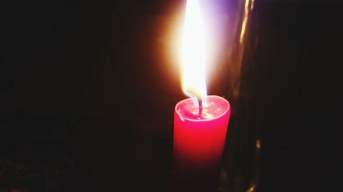 Close-up of lit candle in dark room