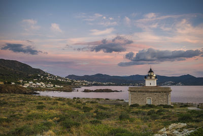 Lighthouse amidst buildings against sky