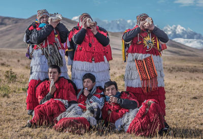 Group of people sitting on field