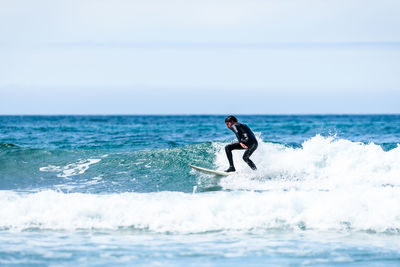 Side view of man in sea against sky