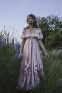 Full length of woman standing on field against sky