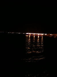 Illuminated lights in sea at night