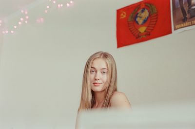 A woman stands in front of a window in an apartment