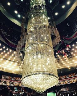 Low angle view of illuminated chandelier hanging at night