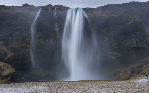 Scenic view of waterfall against sky