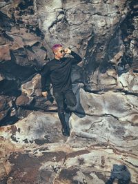 Full length of young man standing on rock