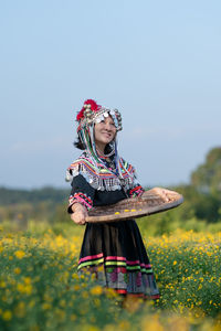 Woman with umbrella standing on field