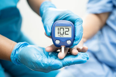 Midsection of doctor holding clock