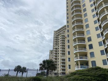 Low angle view of buildings against cloudy sky