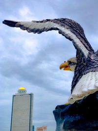 Low angle view of bird flying against sky