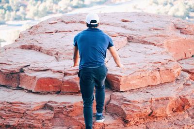 Rear view of man standing on rock