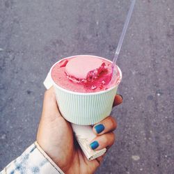 Cropped hand of woman holding ice cream on street