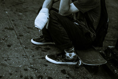 Low section of man sitting on skateboard