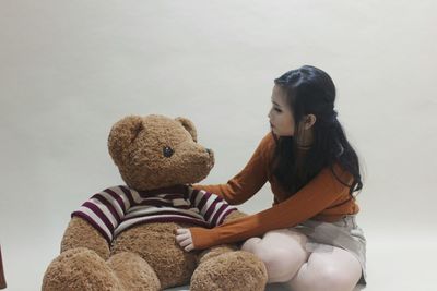 Rear view of girl sitting with toy