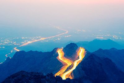 Aerial view of illuminated mountain range against sky