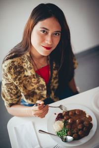 Portrait of young woman holding food