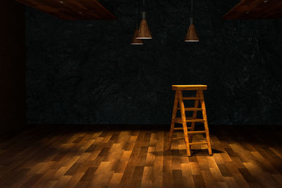 Illuminated electric lamp on floor against wall at home