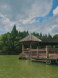 Built structure in lake against cloudy sky