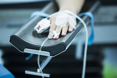 Cropped hand of patient with iv drip at hospital