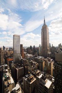 Modern buildings in city against cloudy sky