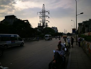 People on road in city against sky