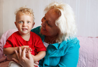 Smiling grandmother with grandson at home