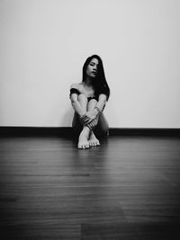 Young woman sitting on wall