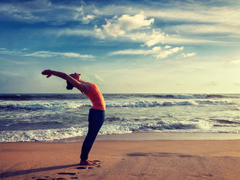 Woman standing on beach against sky
