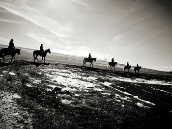 People riding horses on sky