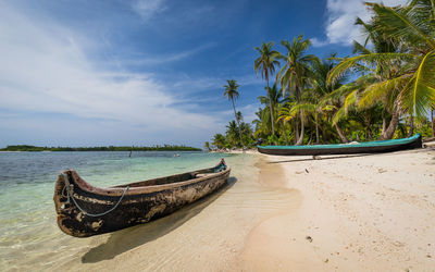 Boats moored at beach against sky