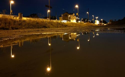 Illuminated street light against sky at night