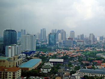 Aerial view of buildings in city against sky