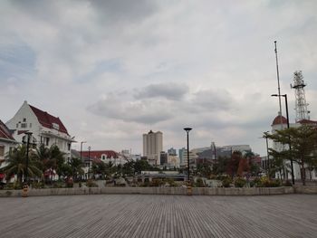 Buildings in city against cloudy sky