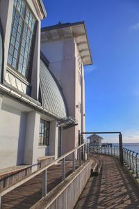 Building by sea against clear blue sky