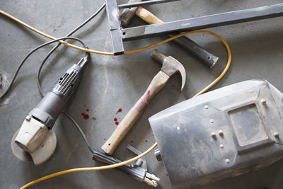 The tools of a worker welder lie on the floor with drops of blood, safety