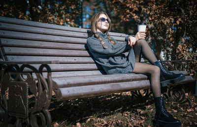 Woman sitting on bench in park