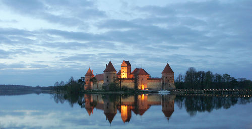 Reflection of buildings in lake at sunset